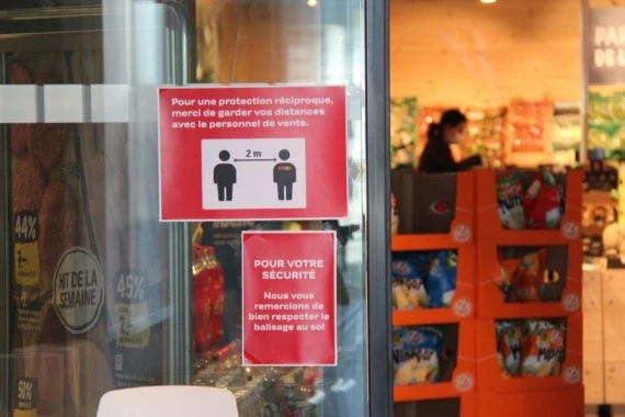A sign reminding people to keep social distance is seen on the door of a supermarket in Geneva, Switzerland, on April 14, 2020.  (Xinhua/Nie Xiaoyang)