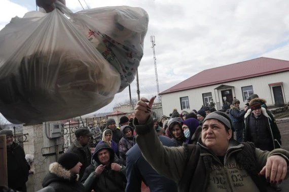 Local residents receive humanitarian aid in Donetsk on March 6, 2022. (Photo by Victor/Xinhua)