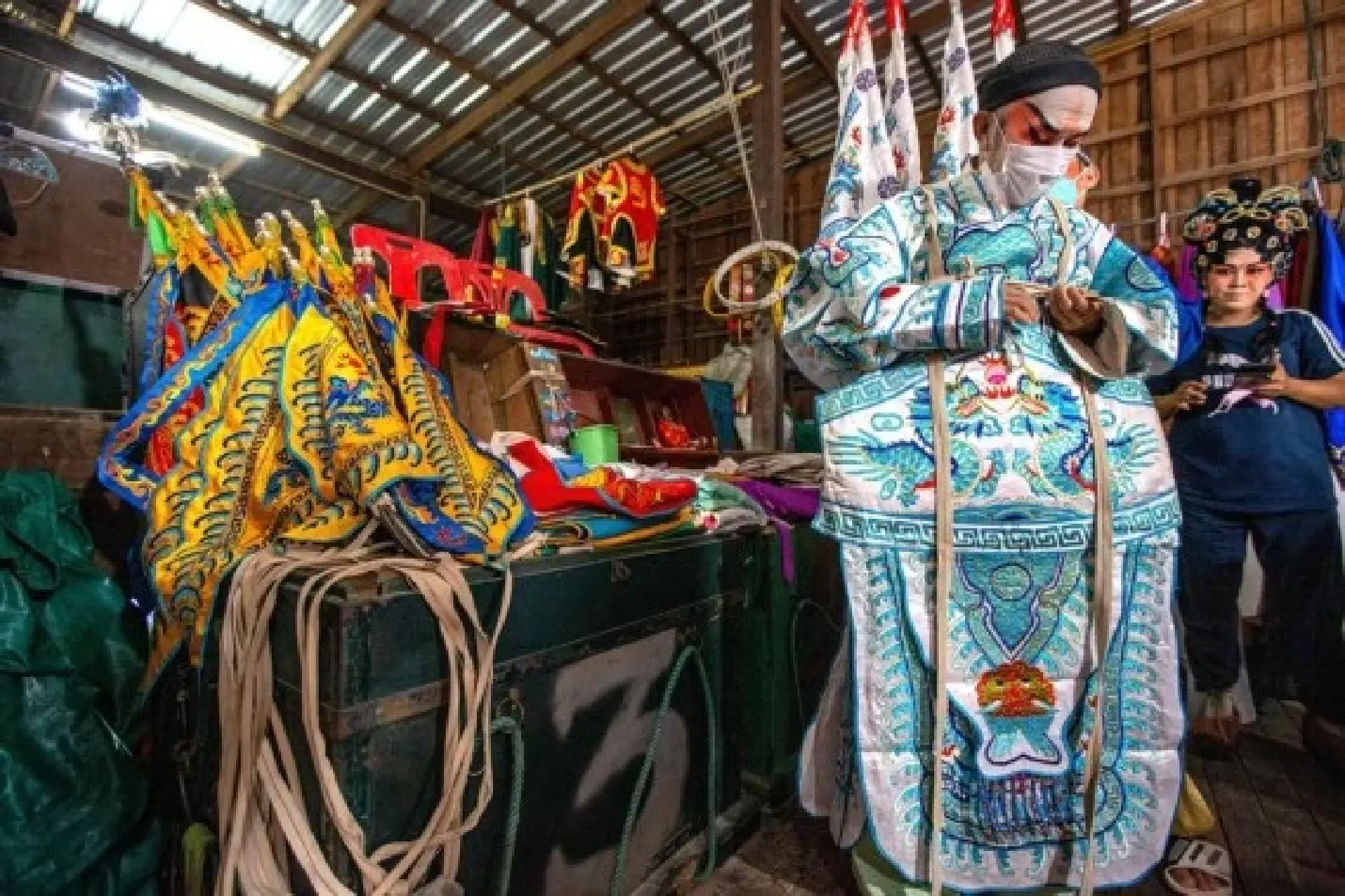 A Chaozhou opera actor puts on costumes backstage in Nakhon Sawan, Thailand, March 24, 2022. (Xinhua/Wang Teng)