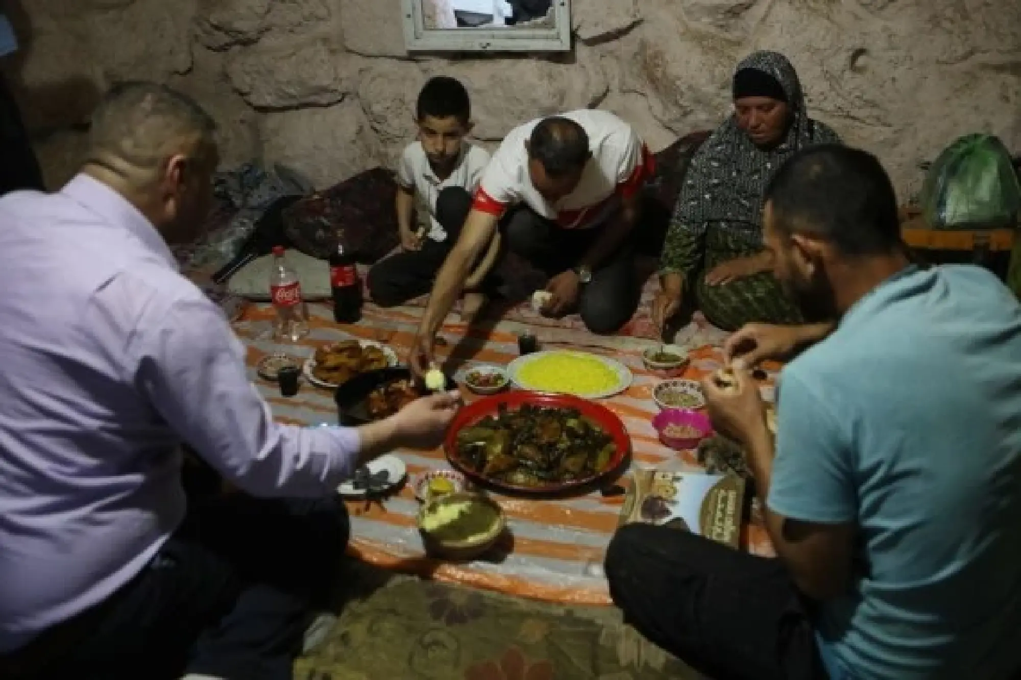 Members of the al-Tell family have their iftar inside a cave at Khirbet Zanuta village, south of the West Bank city of Hebron, on April 17, 2022. (Photo by Mamoun Wazwaz/Xinhua)
