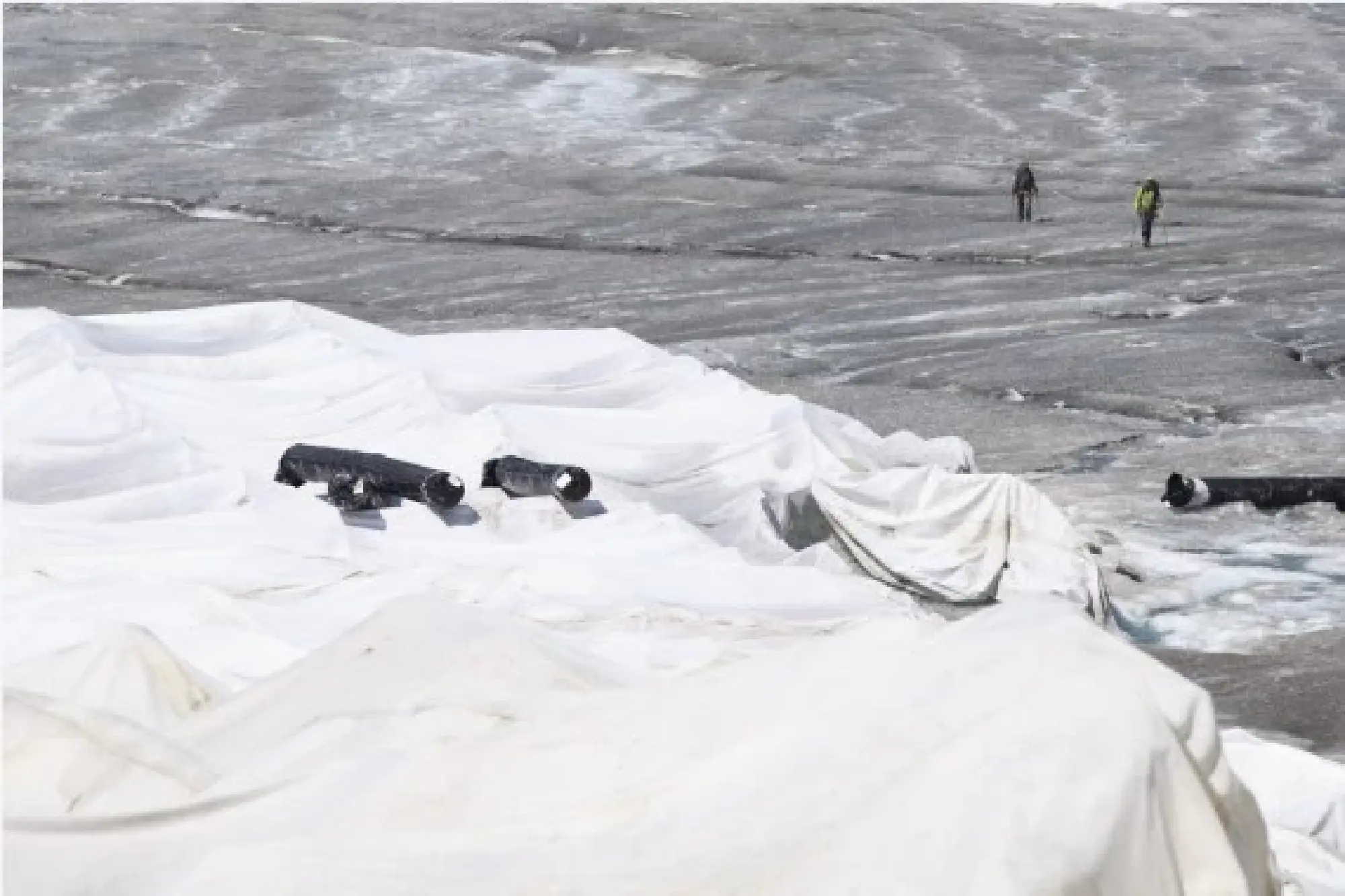  Hikers walk by the Rhone Glacier covered with white blankets near the Furka Pass in Switzerland, Aug. 5, 2018. (Xinhua/Xu Jinquan)
