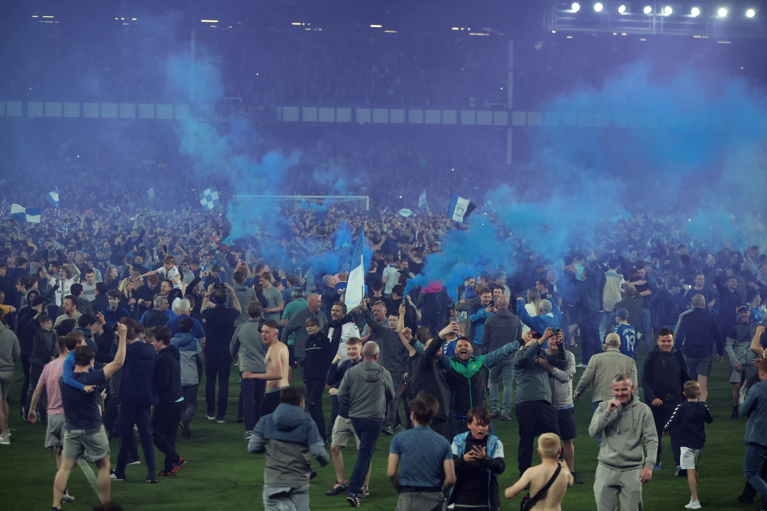  Everton fans invade the pitch after the match as they celebrate avoiding relegation from the Premier League