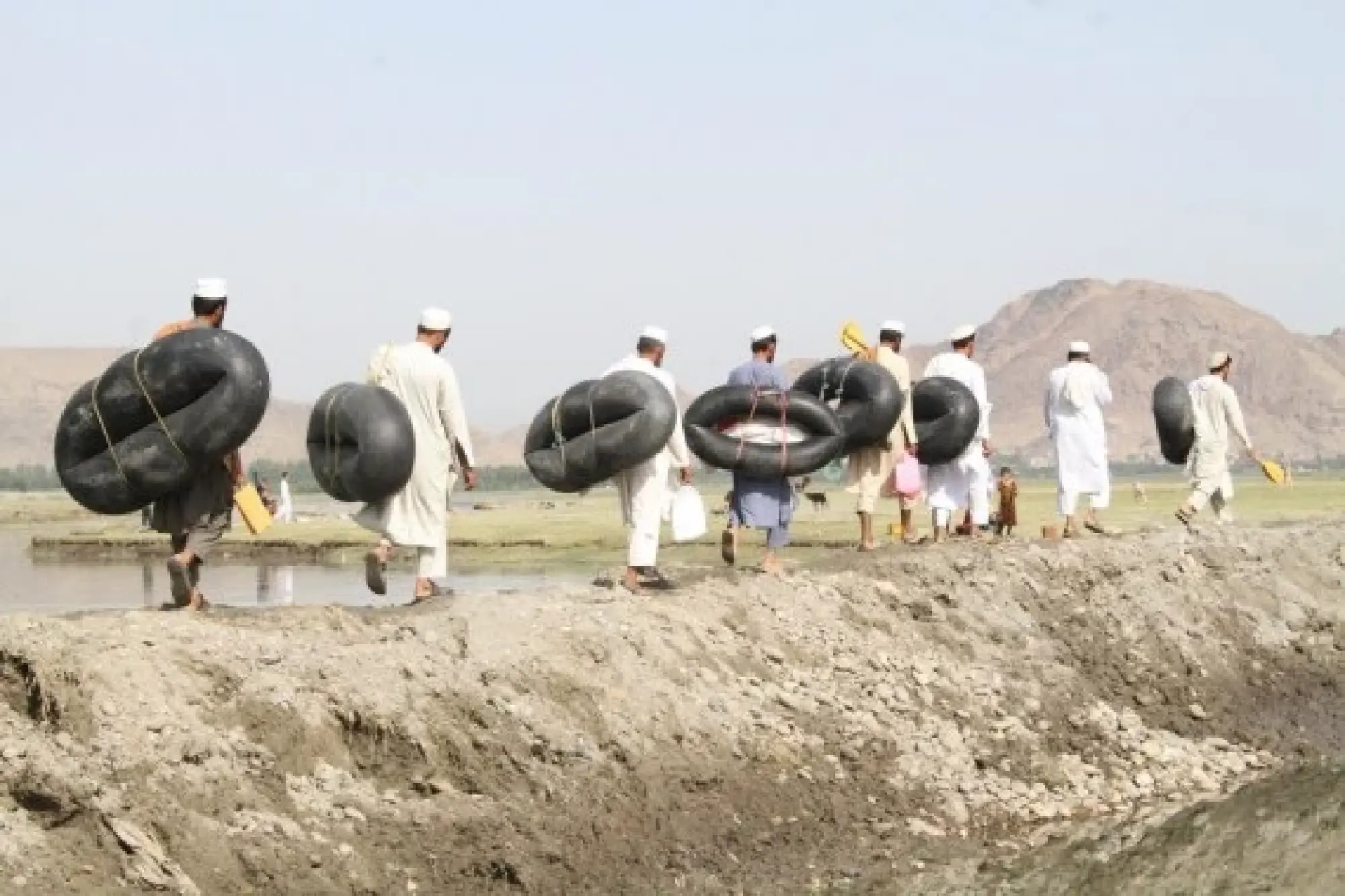 Local teachers cross a river by leather rafts to get to school in Nangarhar province, Afghanistan, June 11, 2022. (Photo by Hamidullah/Xinhua)