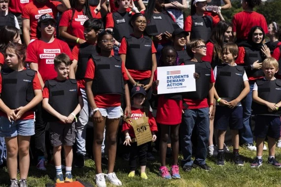 Students wearing bulletproof vests hold a rally near the Capitol Reflecting Pool in Washington, D.C., the United States, June. 6, 2022. (Photo by Aaron Schwartz/Xinhua)