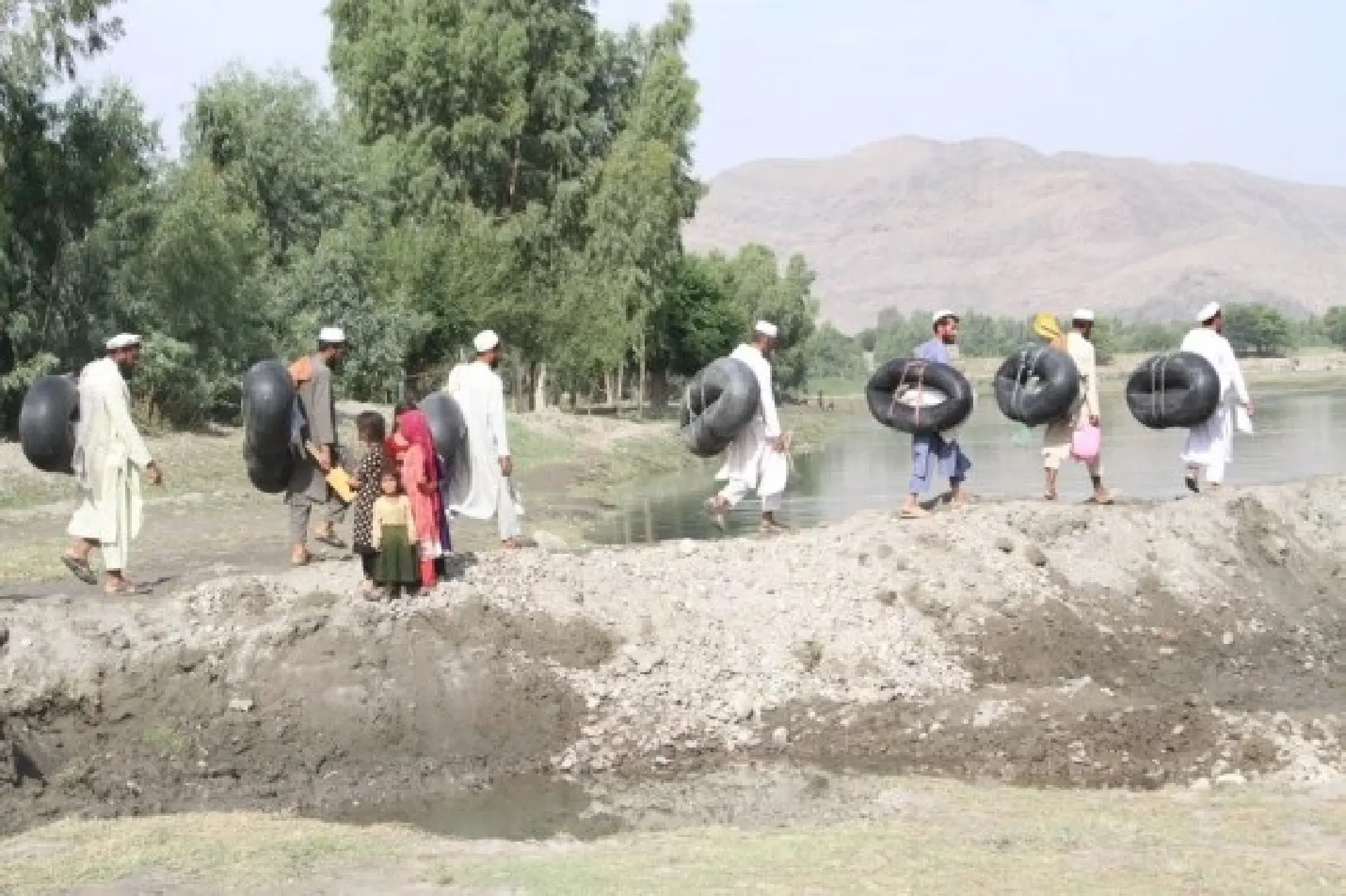Local teachers cross a river by leather rafts to get to school in Nangarhar province, Afghanistan, June 11, 2022. (Photo by Hamidullah/Xinhua)