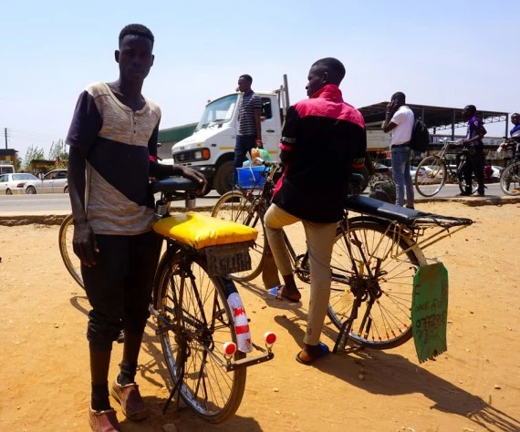 shows bicycle taxi riders waiting for customers in Petauke district, Eastern Province, Zambia. 