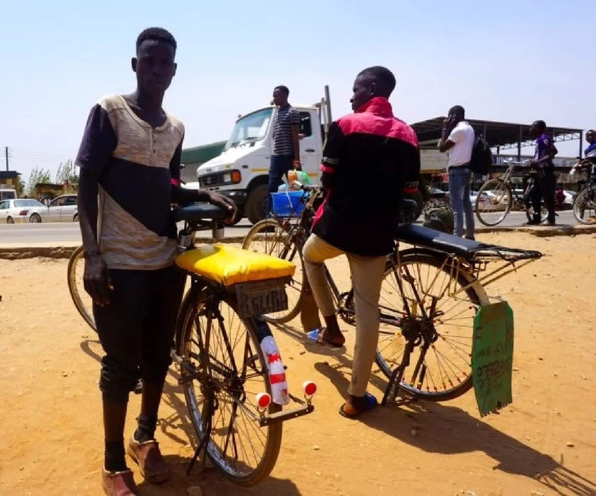 shows bicycle taxi riders waiting for customers in Petauke district, Eastern Province, Zambia. 