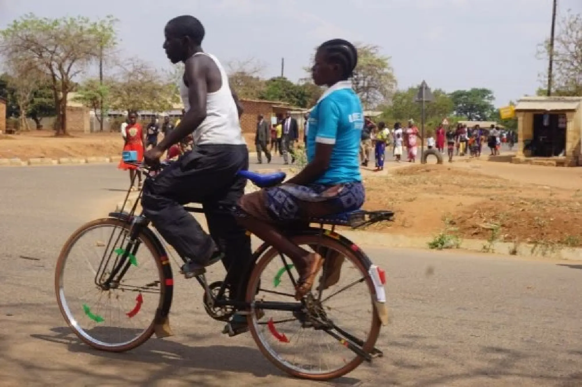 shows a bicycle taxi rider and a passenger in Petauke district, Eastern Province, Zambia.