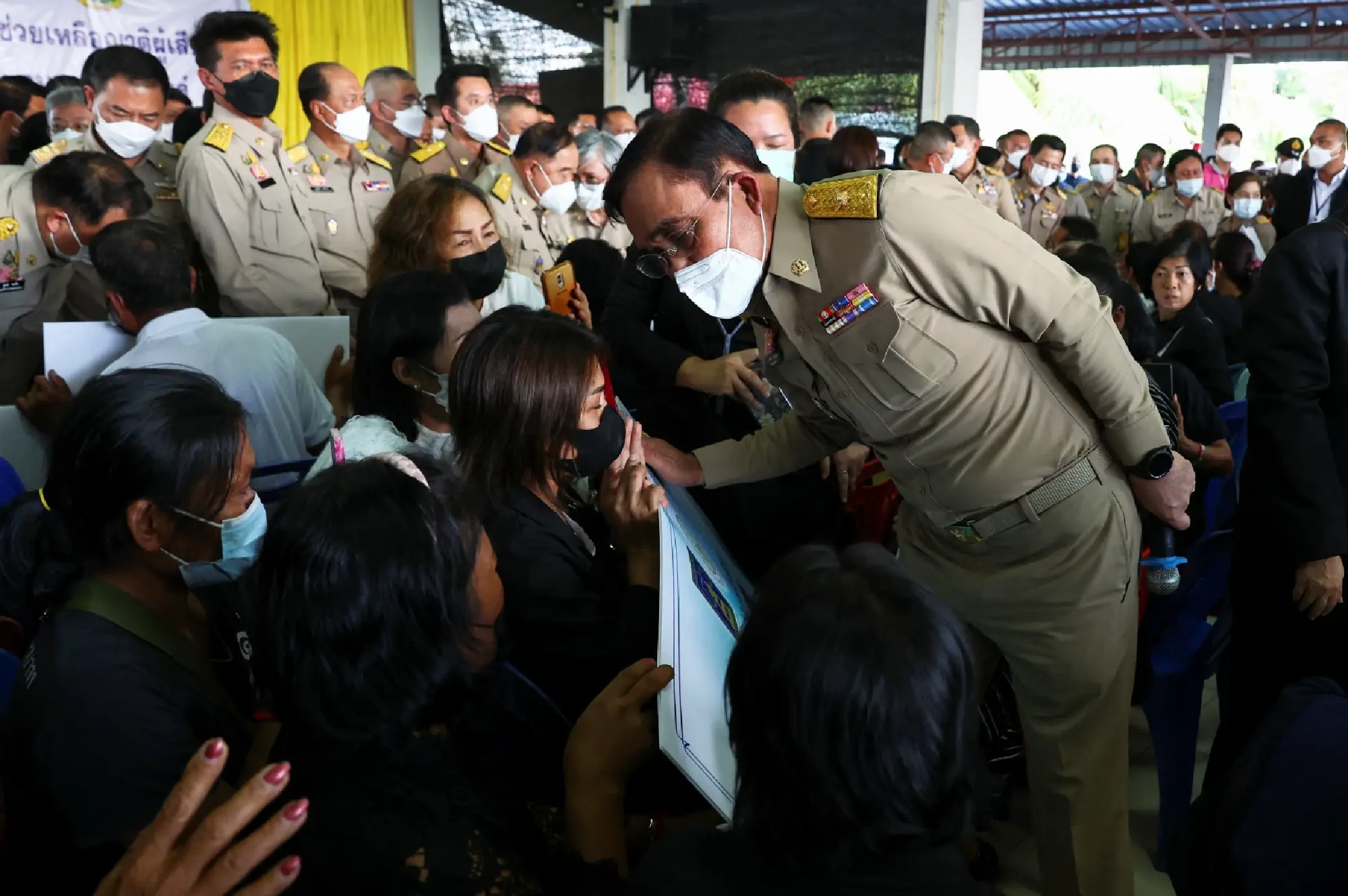 Thailand\'s Prime Minister Prayut Chan-o-cha speaks with family members of the victims outside the day care centre which was the scene of a mass shooting, in the town of Uthai Sawan, in the province of Nong Bua Lam Phu, Thailand