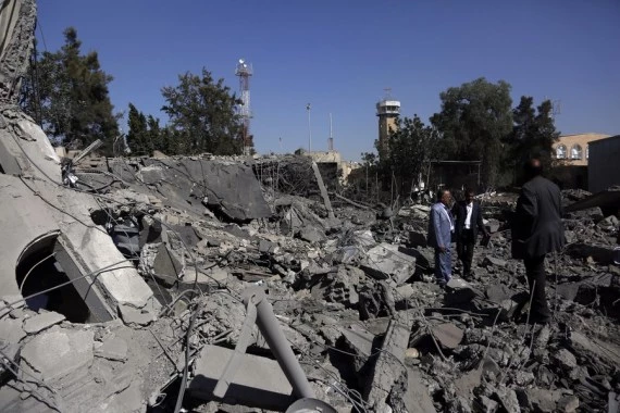 People stand on the debris of a destroyed building inside the Sanaa International Airport in Yemen on Dec. 21, 2021. The Saudi-led coalition involved in a war in Yemen on Monday launched airstrikes on the Sanaa International Airport held by the Yemeni Houthi rebels, the Saudi Press Agency (SPA) reported. (Photo by Mohammed Mohammed/Xinhua)