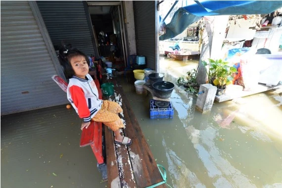  A girl sits over the floodwater outside a house in Ayutthaya, Thailand, on Oct. 18, 2022.