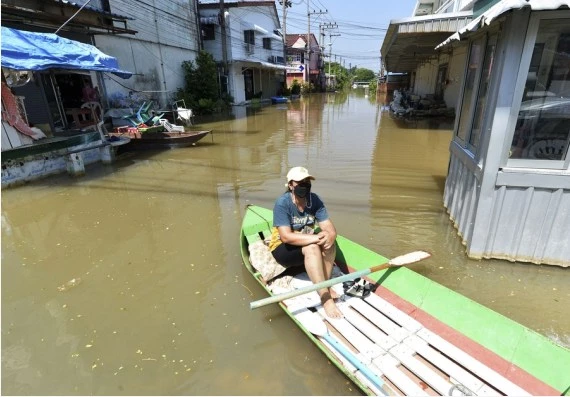 A woman sits on a boat on a flooded street in Ayutthaya, Thailand, on Oct. 18, 2022.