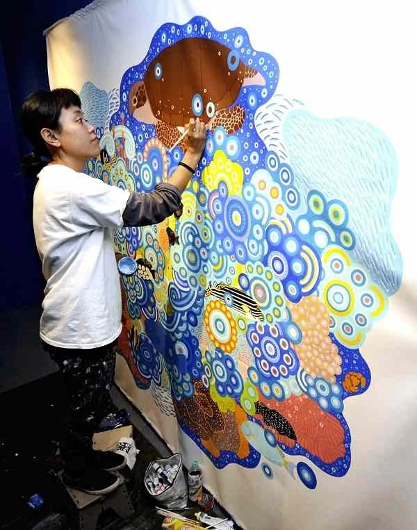 Yume Matsuo paints at Kushimoto Marine Park in Kushimoto, Wakayama Prefecture. The Yomiuri Shimbun