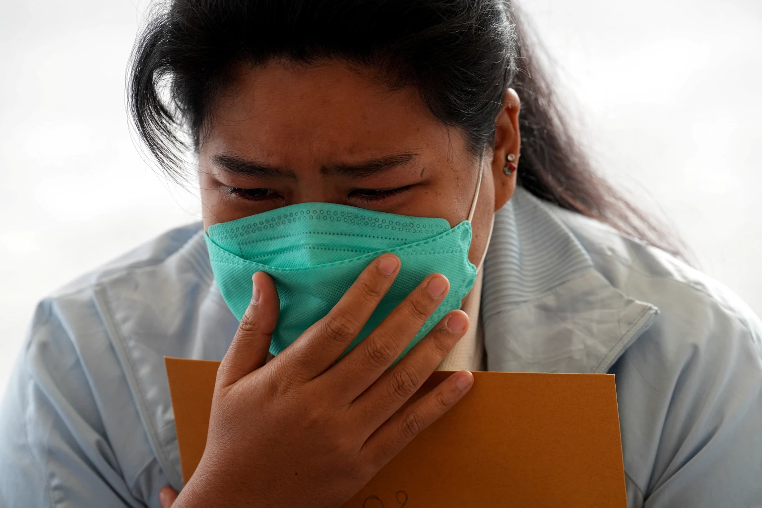Nunthida Kongreung, daughter of victims of the Grand Diamond hotel-casino fire, reacts as she receives documents from officials, in Aranyaprathet district, Sa Kaeo province near Thailand-Cambodia border, December 30, 2022.