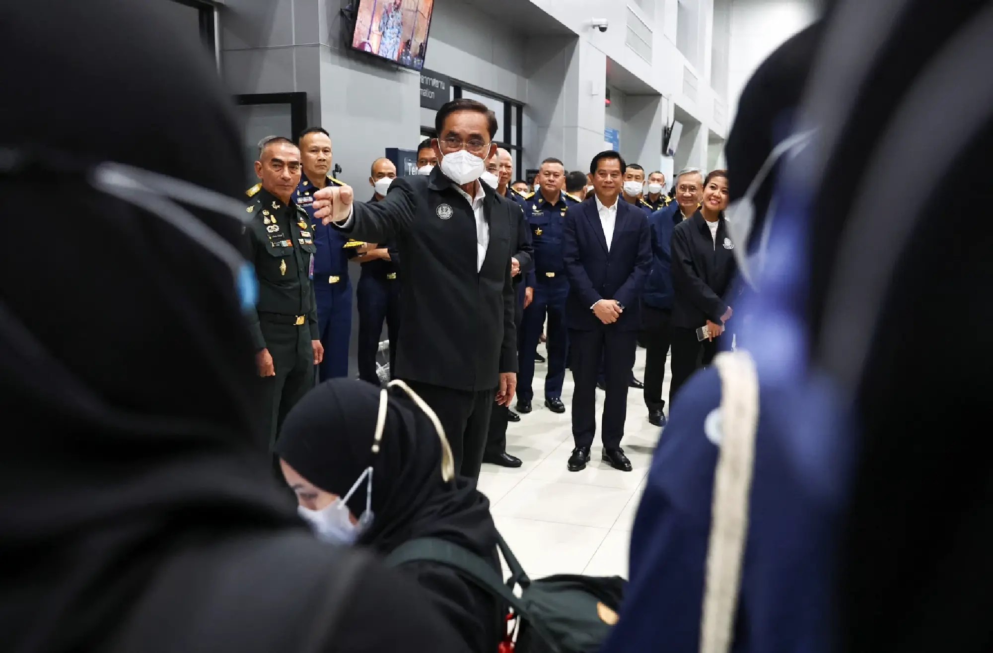 Thailand's Prime Minister Prayuth Chan-ocha gestures as Thai people, who were evacuated from Sudan to escape the conflict, arrive at a Royal Thai Air Force base at the Don Mueang International Airport in Bangkok, Thailand