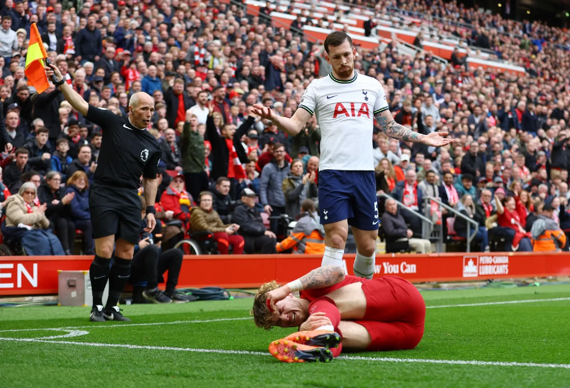 Liverpool's Harvey Elliott reacts after sustaining an injury as Tottenham Hotspur's Pierre-Emile Hojbjerg looks on
