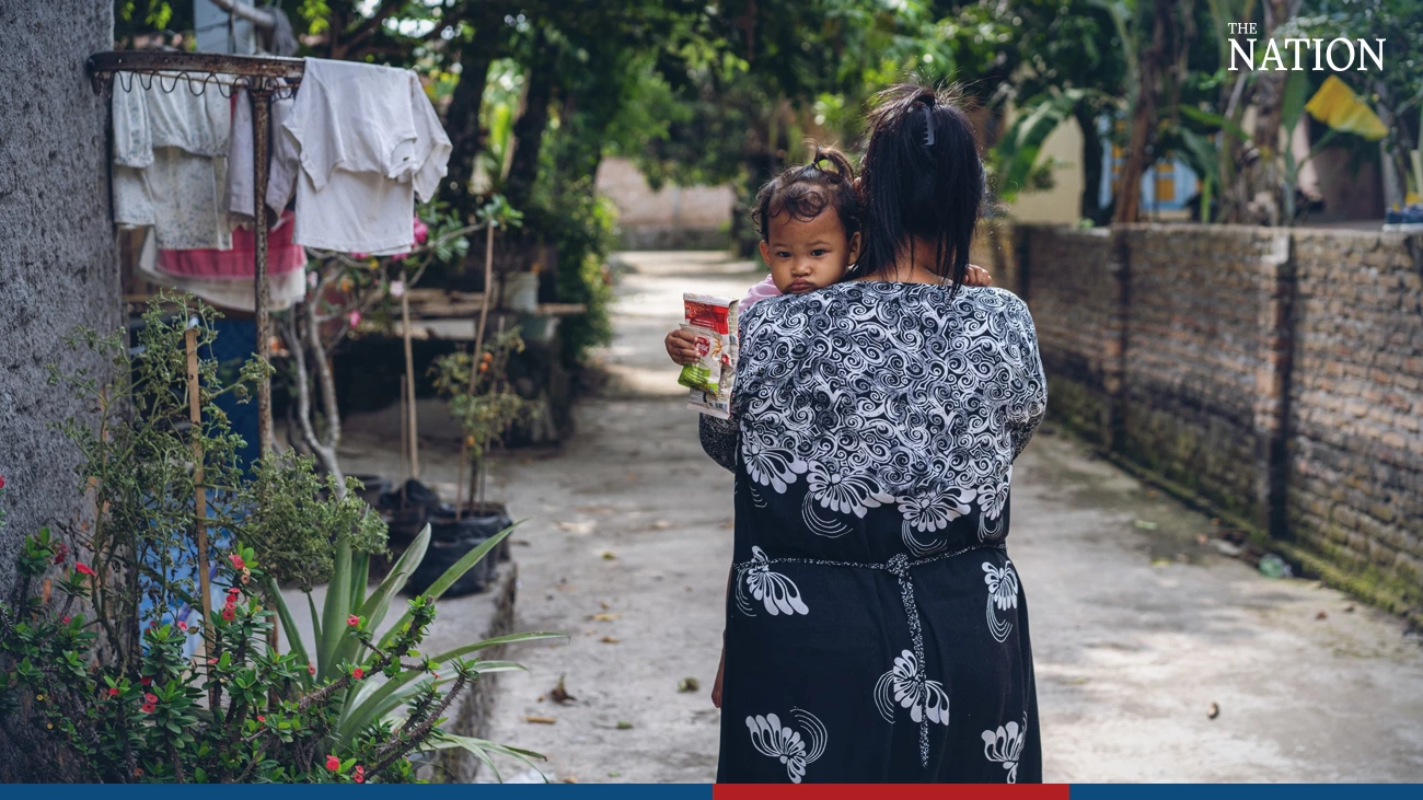 Teresia Lasmita and her two-year-old daughter Shabiya walk home after buying cereal at a corner store in the Wedi district of Klaten, Central Java province, Indonesia.  (Photo courtesy of UNICEF/Ijaza)