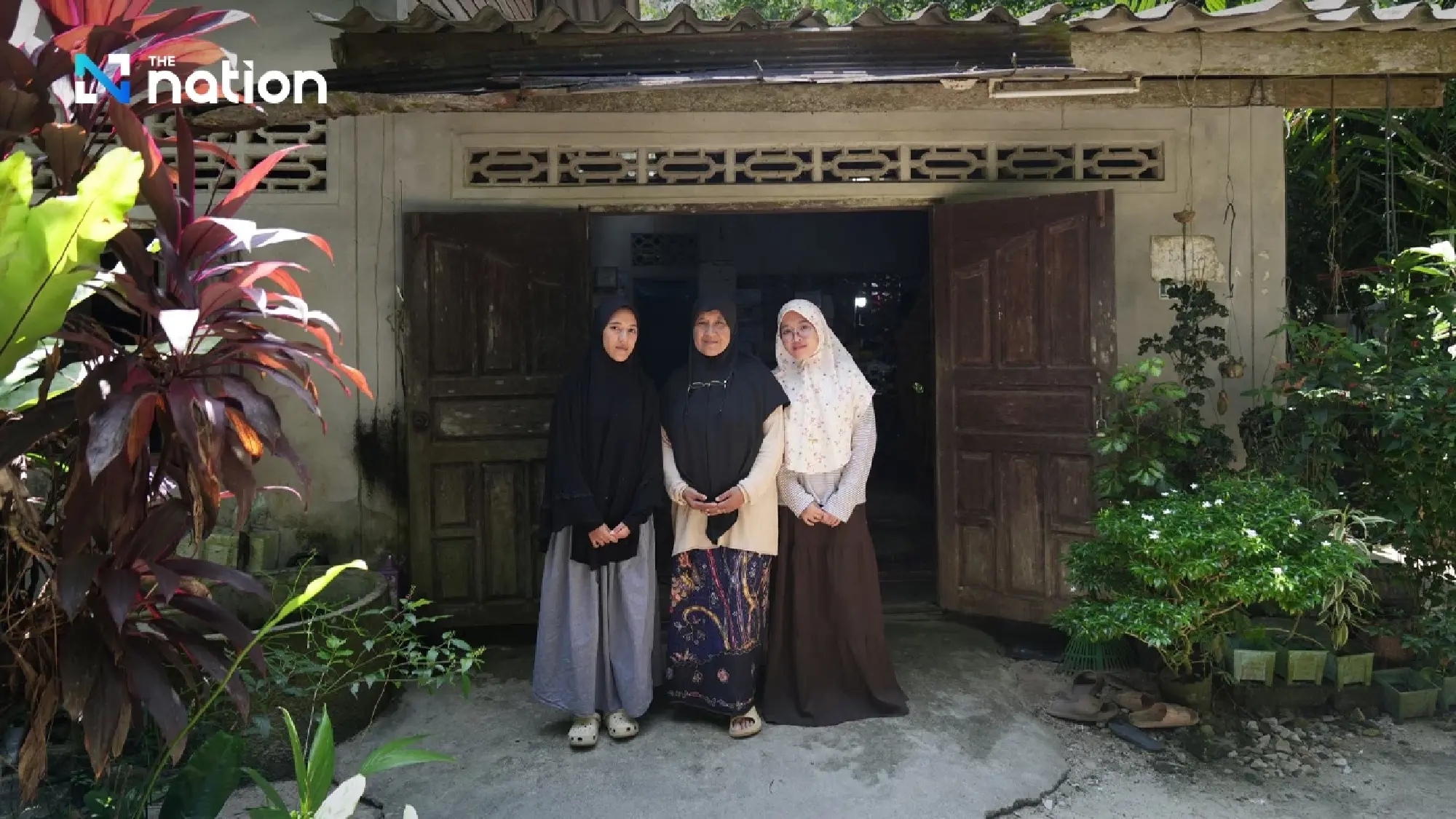 Fadira Tohseutae, her sister Misbah and her mother, Rahimah Saud in front of the house