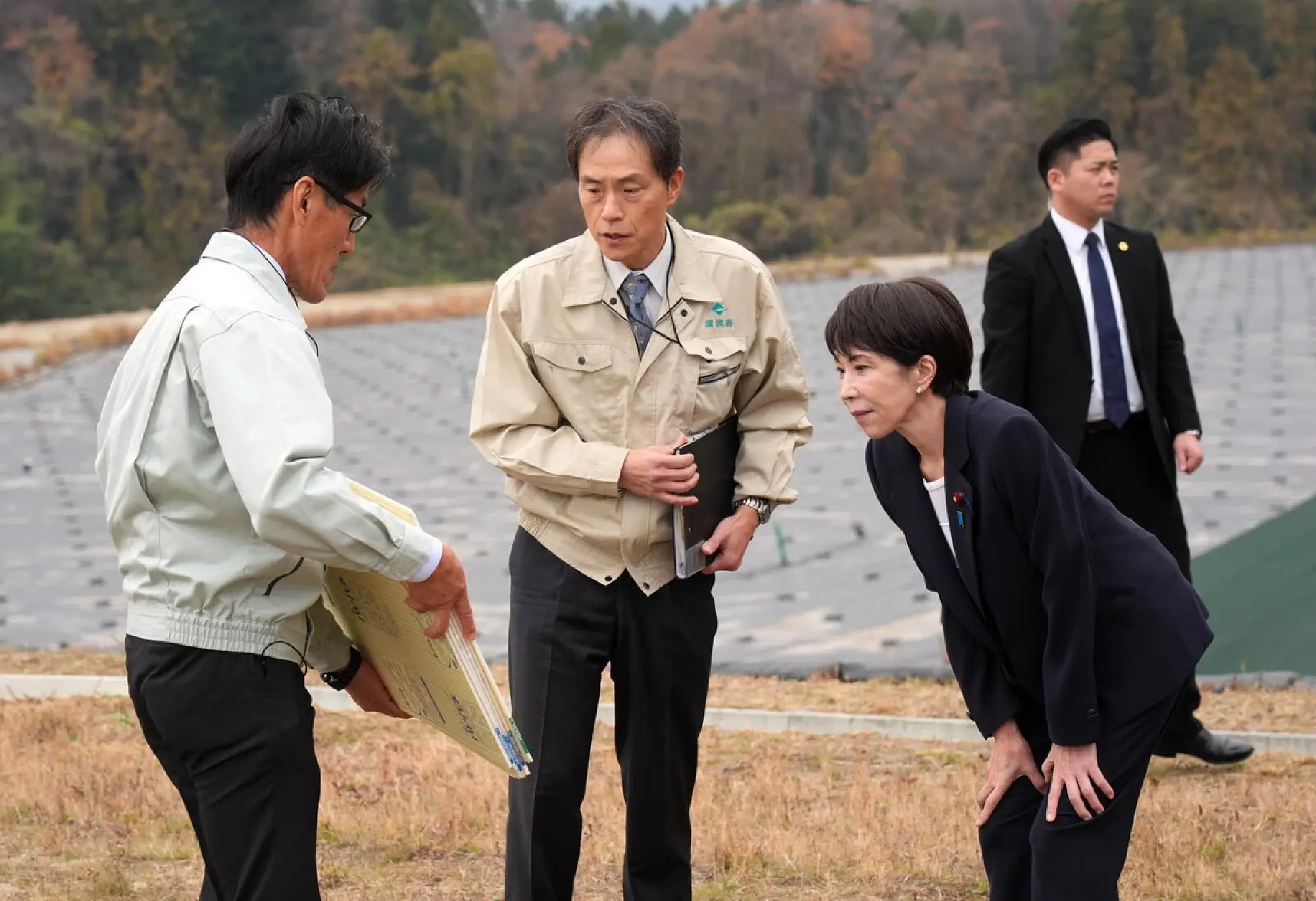 Japanese Prime Minister Sanae Takaichi (right) inspects an interim storage facility for soil from radiation decontamination work in the town of Okuma, Fukushima Prefecture, northesastern Japan, on Tuesday. (Pool photo).