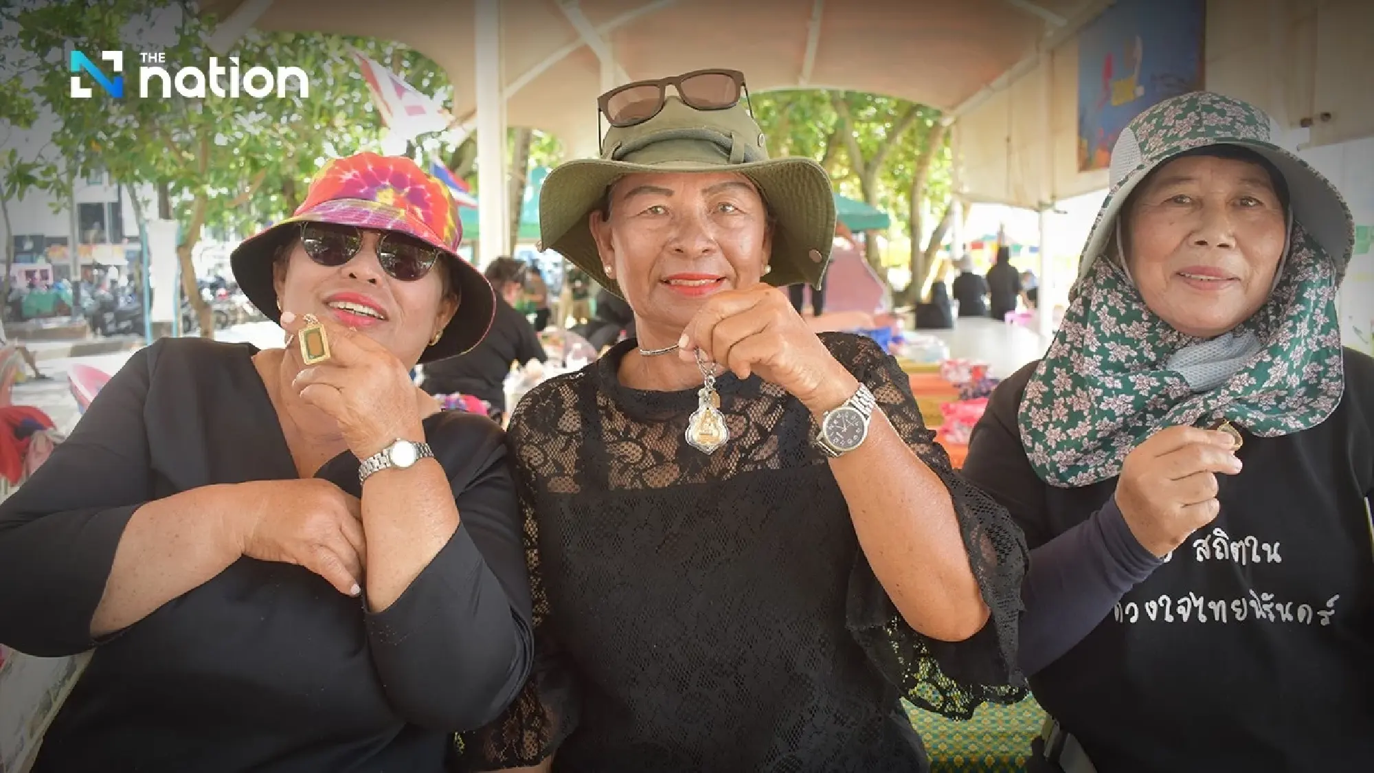 Srinual Khaolek (right), Thaworn Thongren (left), and Jiraporn Thueanthin (centre) show amulets they say they prayed to at the time of the tsunami 21 years ago.