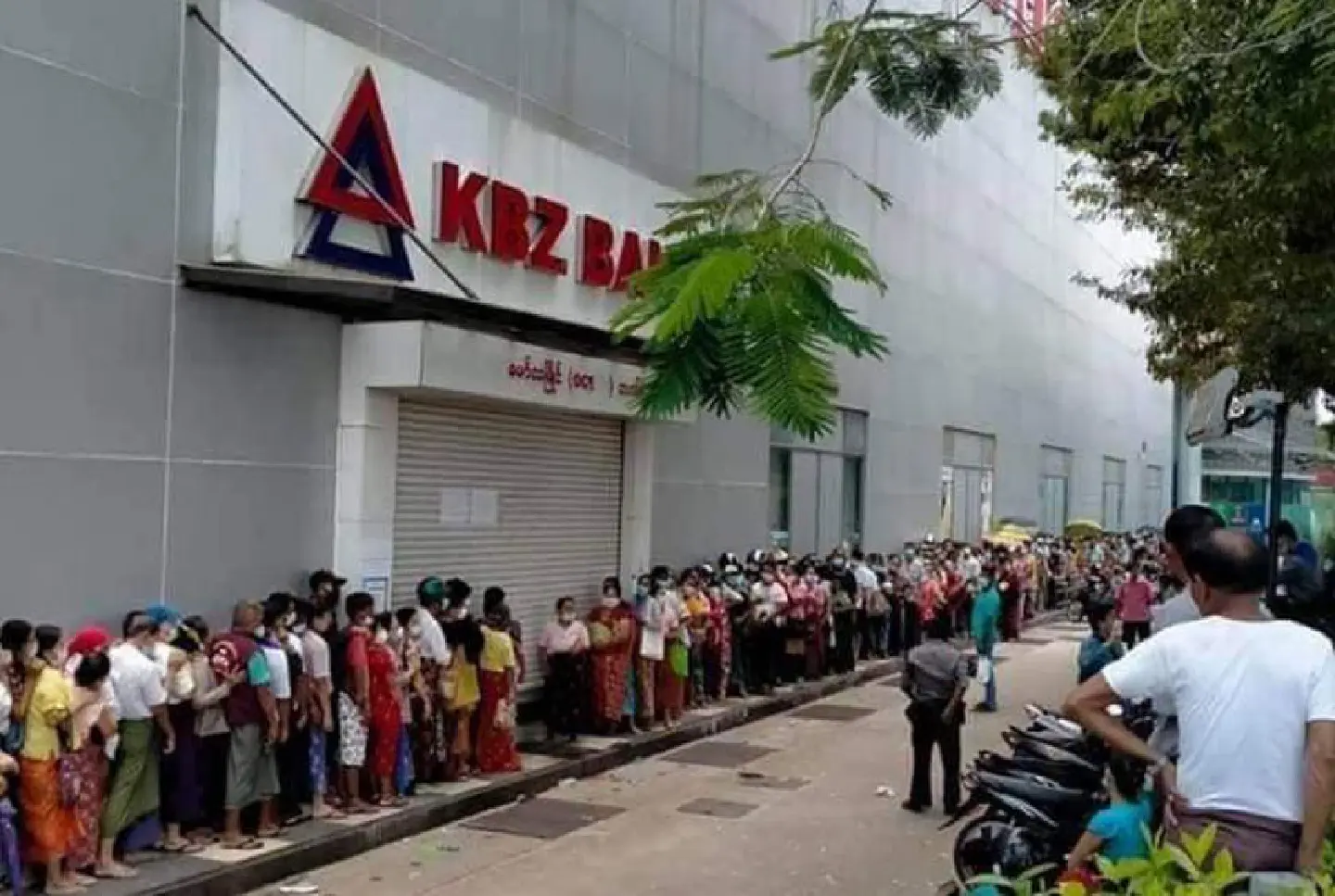 [Myanmar] Policeman fires into air to control the crowd queued at KBZ Bank in Mawlamyaing