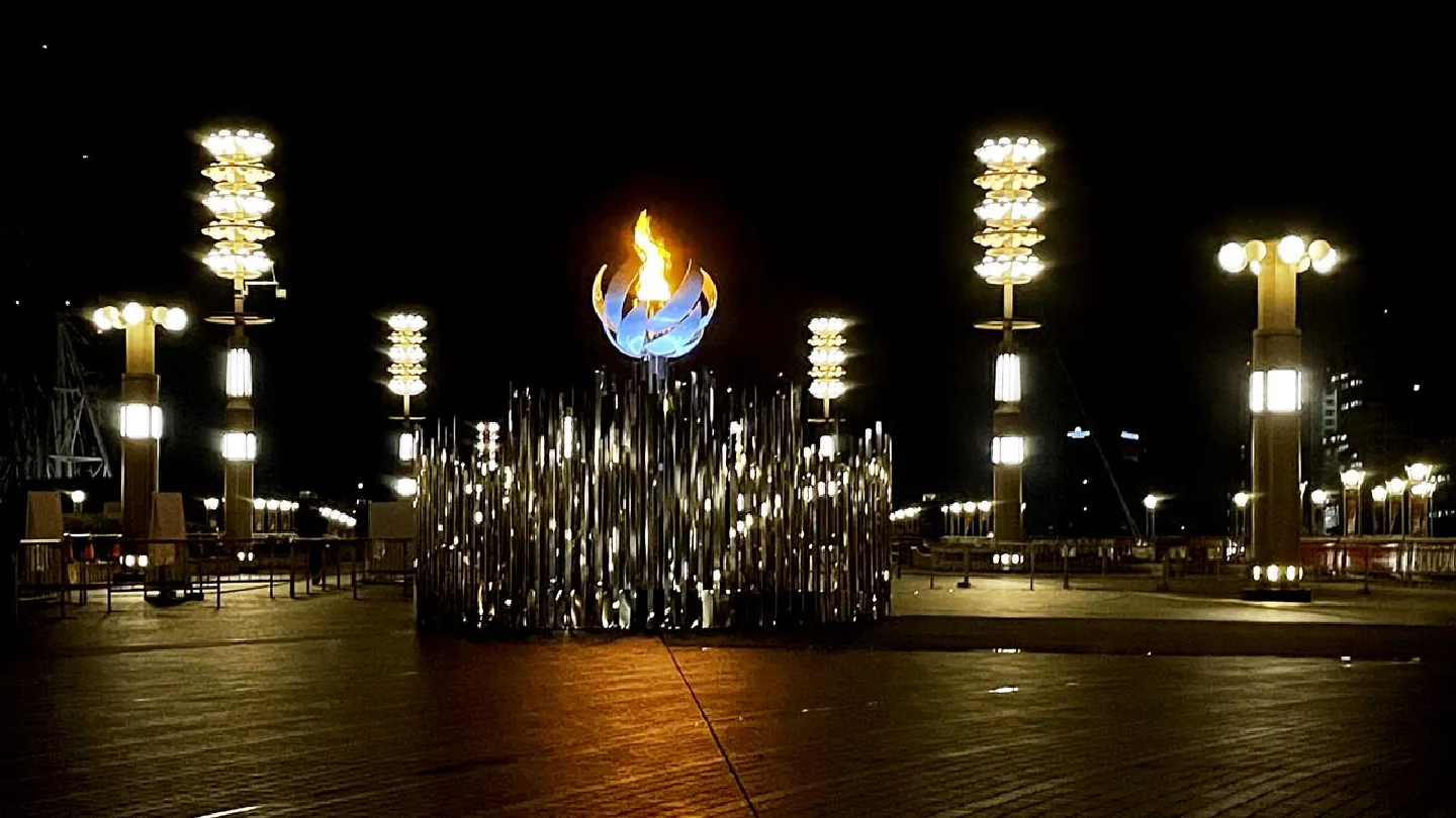 Late at night, on a bridge in Tokyo Bay, the Olympic flame burns alone Late at night, on a bridge in Tokyo Bay, the Olympic flame burns alone