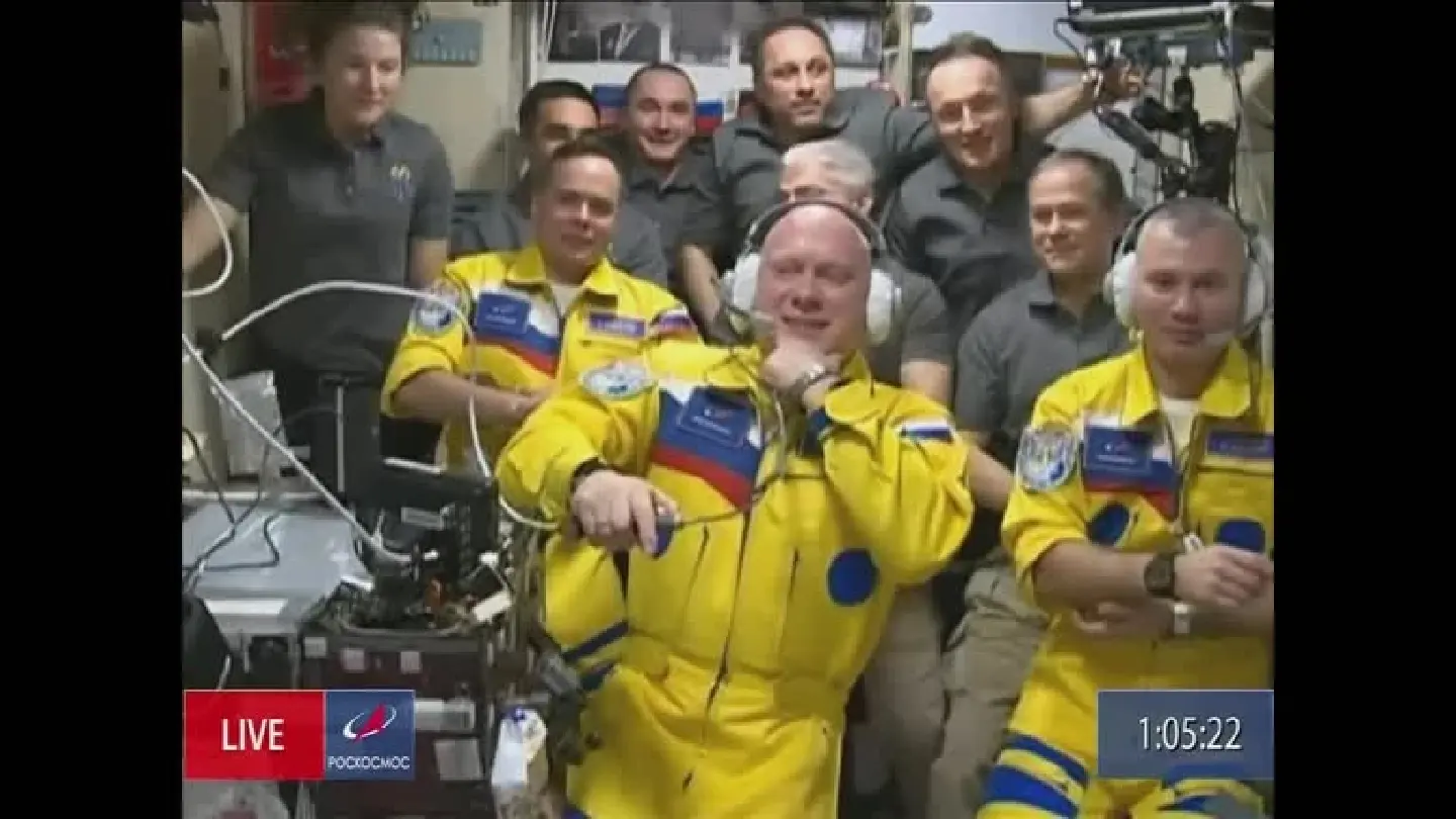 Russian space crew dock with ISS, wear yellow suits resembling Ukrainian flag