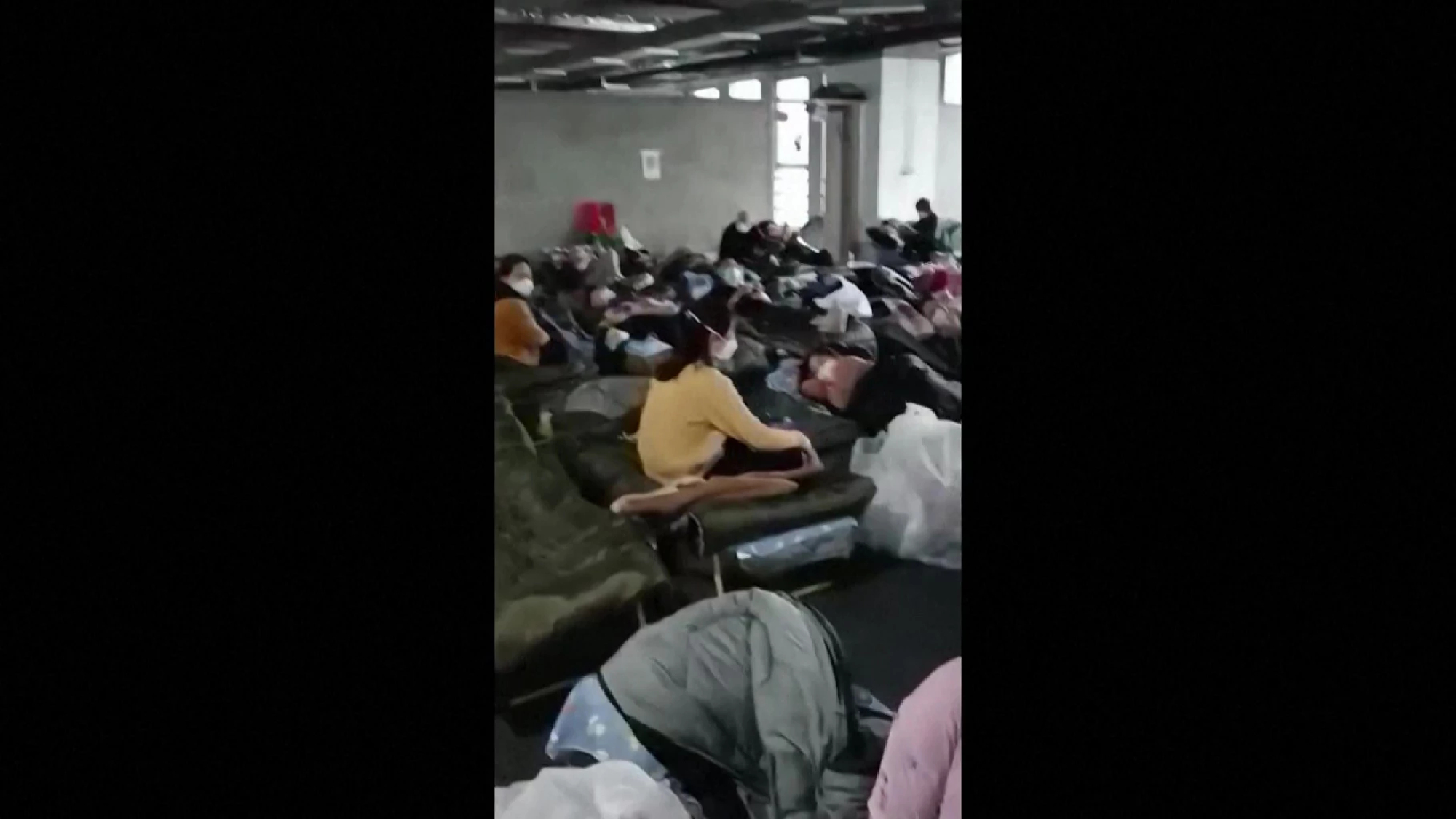 Quarantined COVID patients sleep in camp beds less than a metre apart in Shanghai