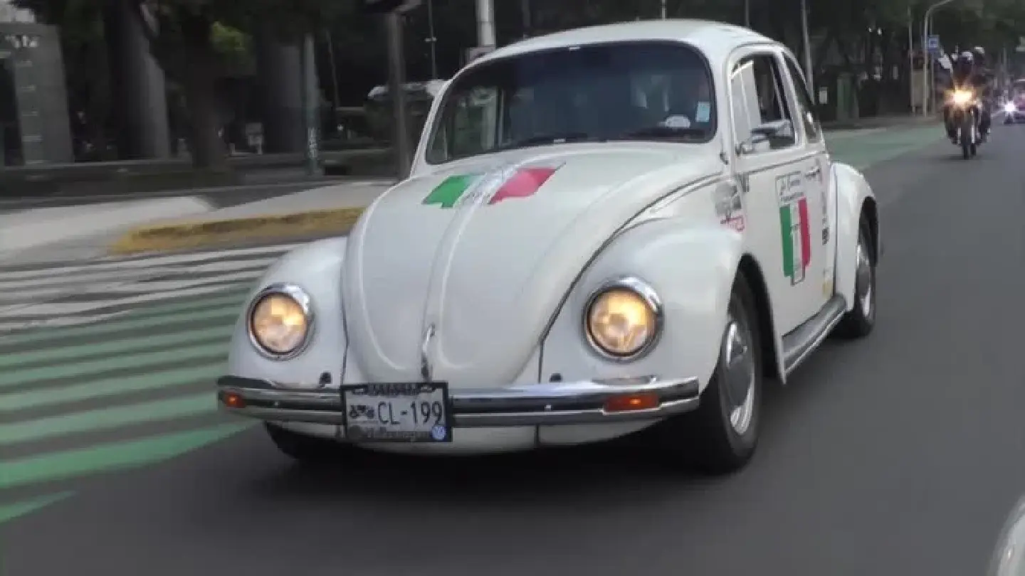 Parade of Volkswagen Beetles cruise Mexico City streets