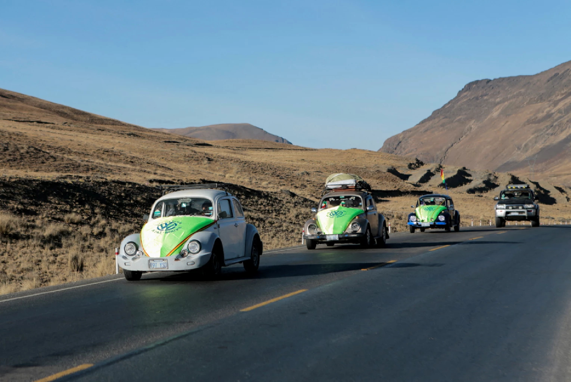 VW Beetle convoy cruises Bolivia's scenic mountains