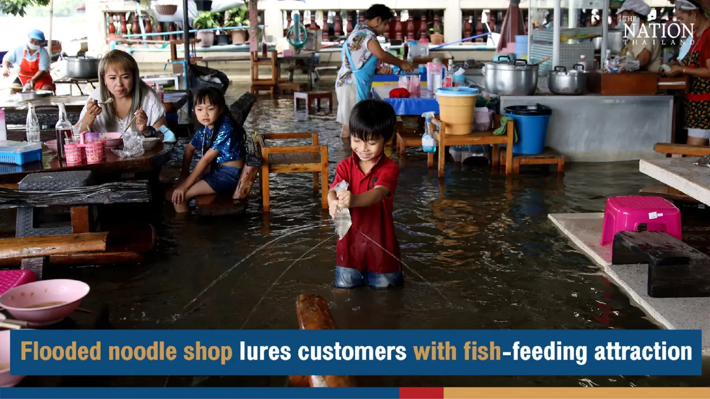 Flooded noodle shop lures customers with fish-feeding attraction