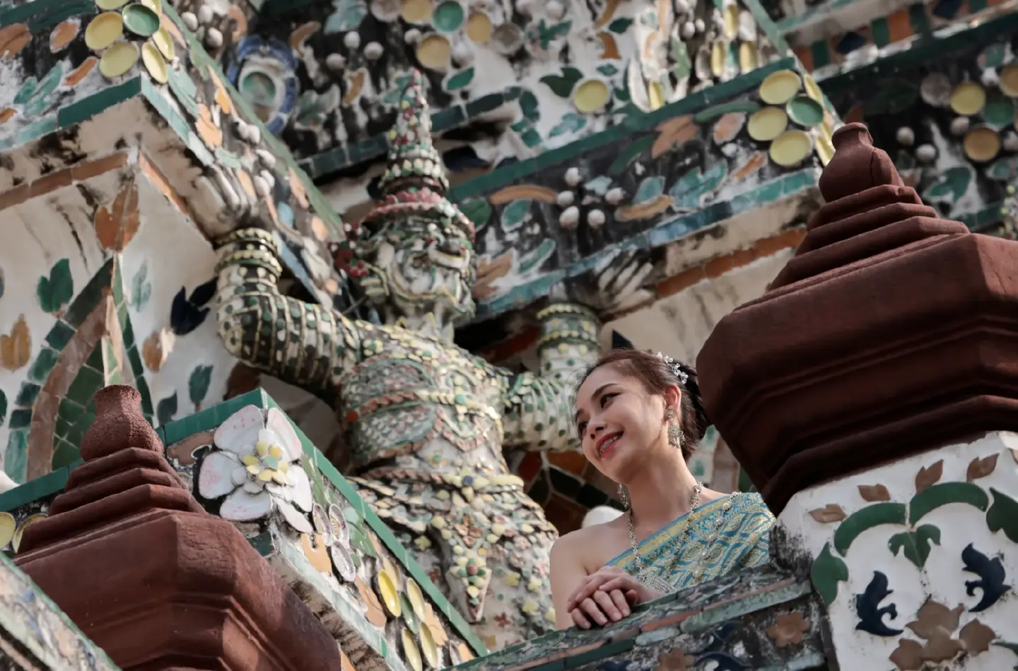 Tourist dressed in a traditional Thai costume visits Wat Arun temple in Bangkok
