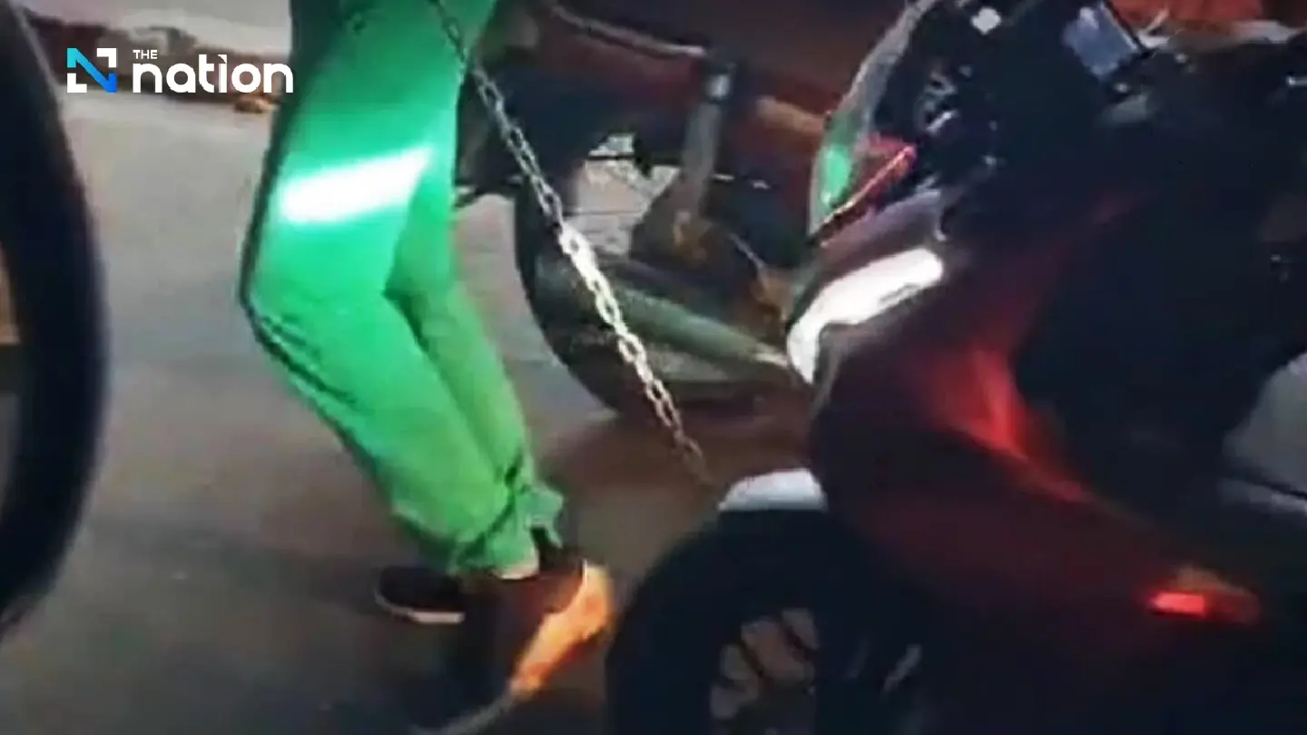 Unfazed by police lock, farang tourists pull bike away in Phuket